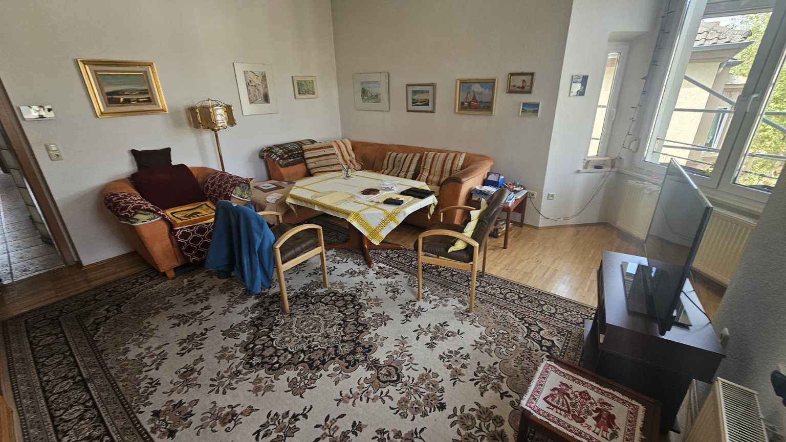 Wohnzimmer mit Sofa, Sesseln und Teppichen vor der Wohnungsauflösung durch BAREXA